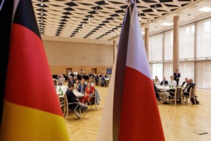 Bild auf das Publikum des deutsch-polnischer Expertenworkshops; im Vordergrund sind die Flaggen von Deutschland und Polen zu sehen