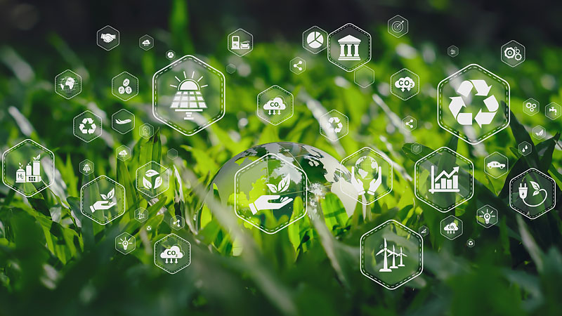 Das Foto zeigt vor grünem Hintergrund zahlreiche Symbole, die für verschiedene Bewertungskriterien stehen, wie Nutzung erneuerbarer Energien, Kreislaufwirtschaft, Wachstum, Umweltschutz oder Kultur.